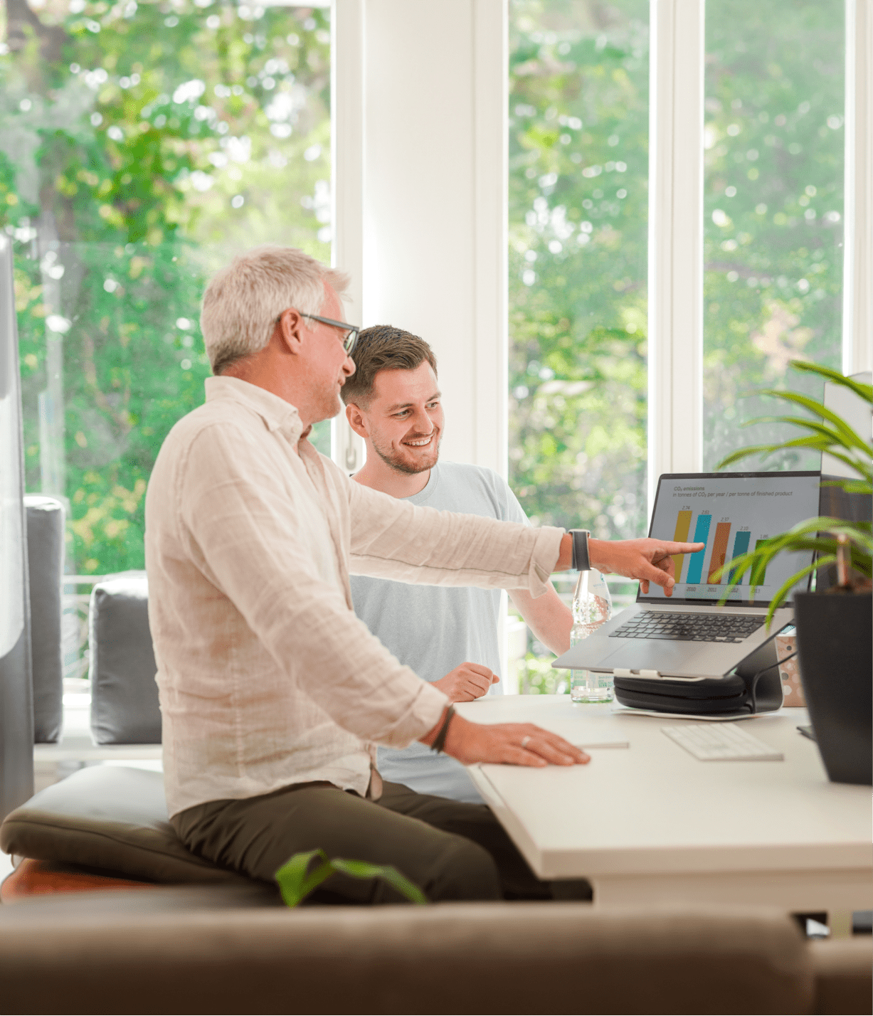 Two men looking at a laptop with a graph. Career opportunities.